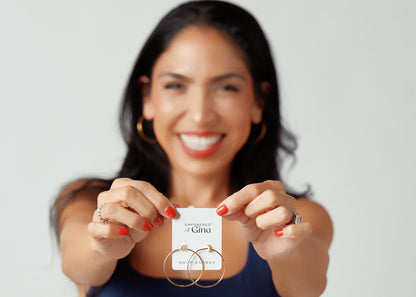 Woman holding a product with a label against a plain background